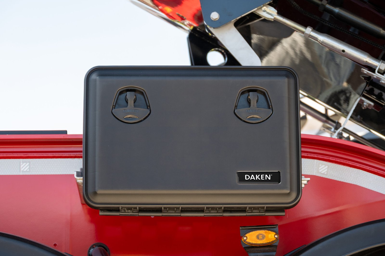 Daken Just - Cassetta porta attrezzi in plastica in primo piano, chiusa, di colore nero, installata su mezzo, foto frontale ravvicinata